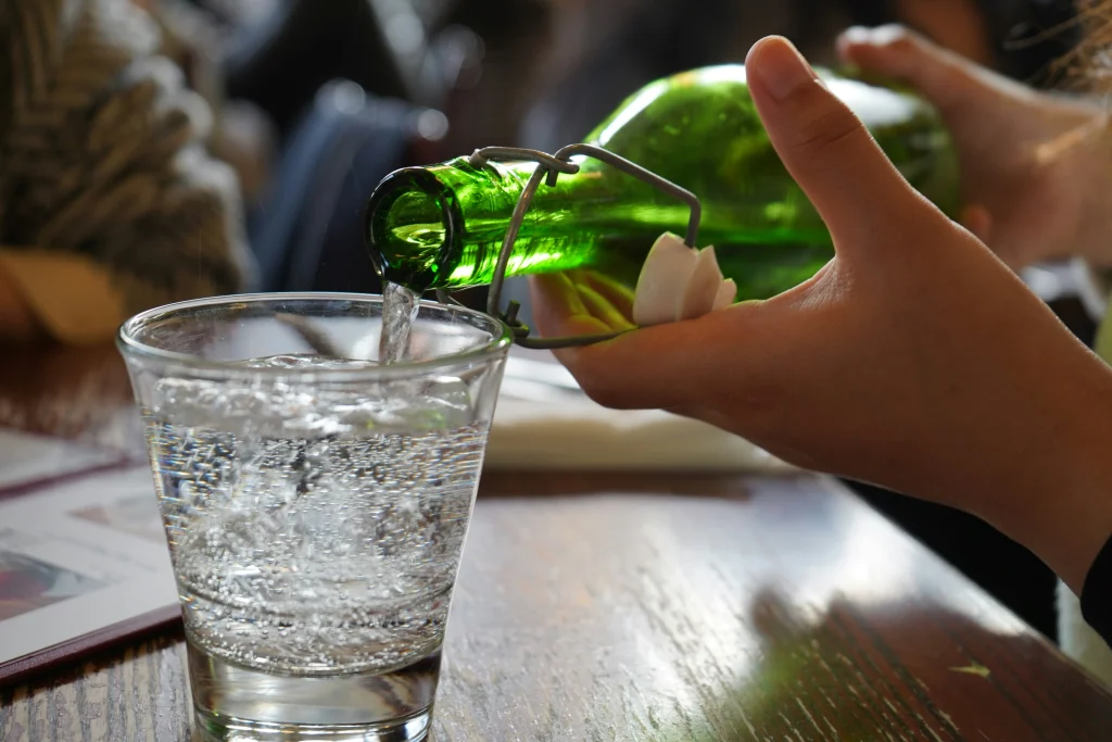 飲食店のテーブルの上でグラスに水を注ぐ