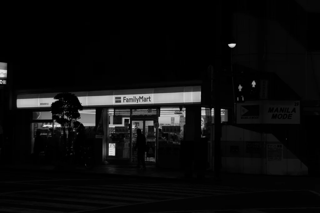 夜の暗闇の中で光を放つファミリーマートの店舗