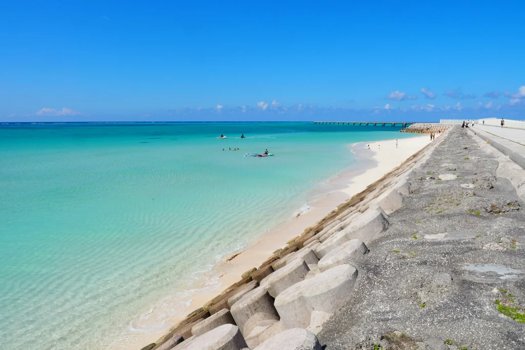 透き通るような美しい海とテトラポットが並ぶ海岸線の風景