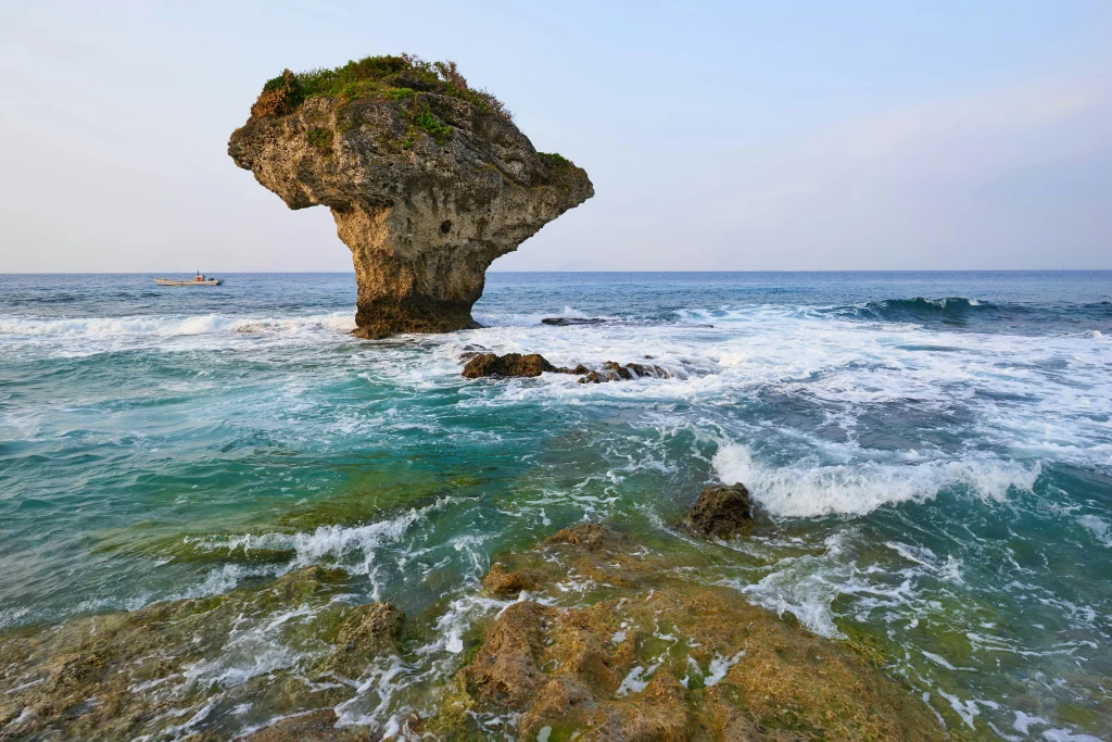 美しい海岸に佇む、キノコのような独特な形状をした大きな奇岩の風景