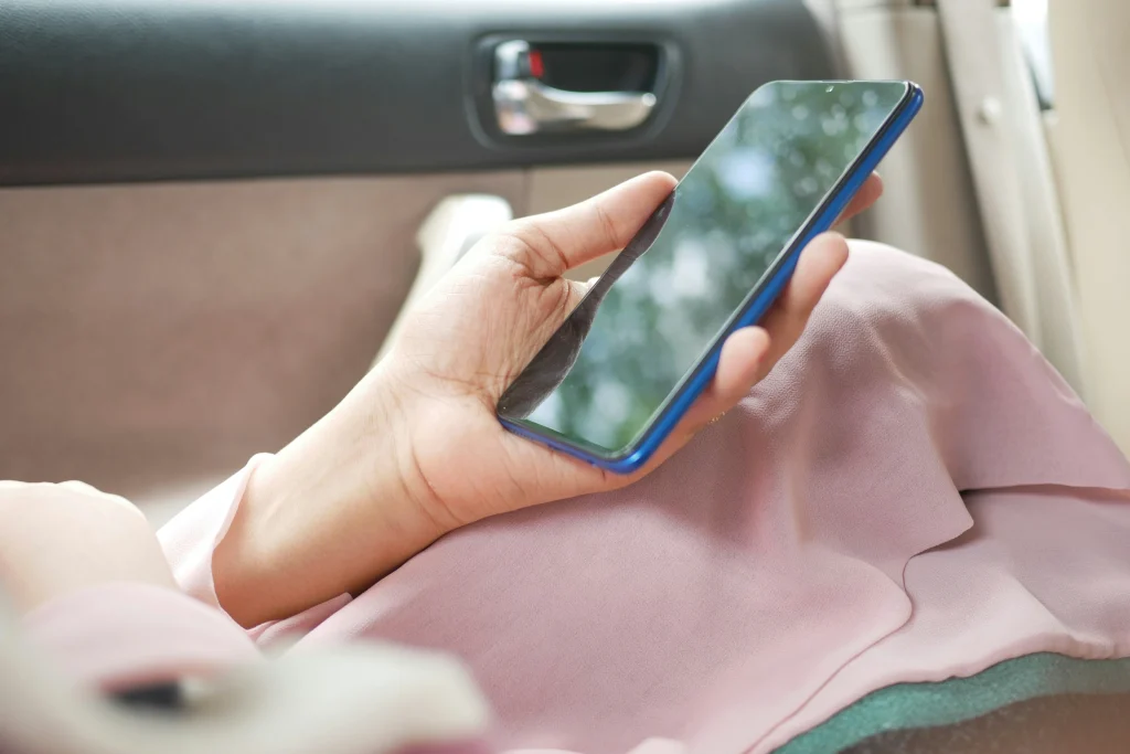車内でスマートフォンをもつ女性