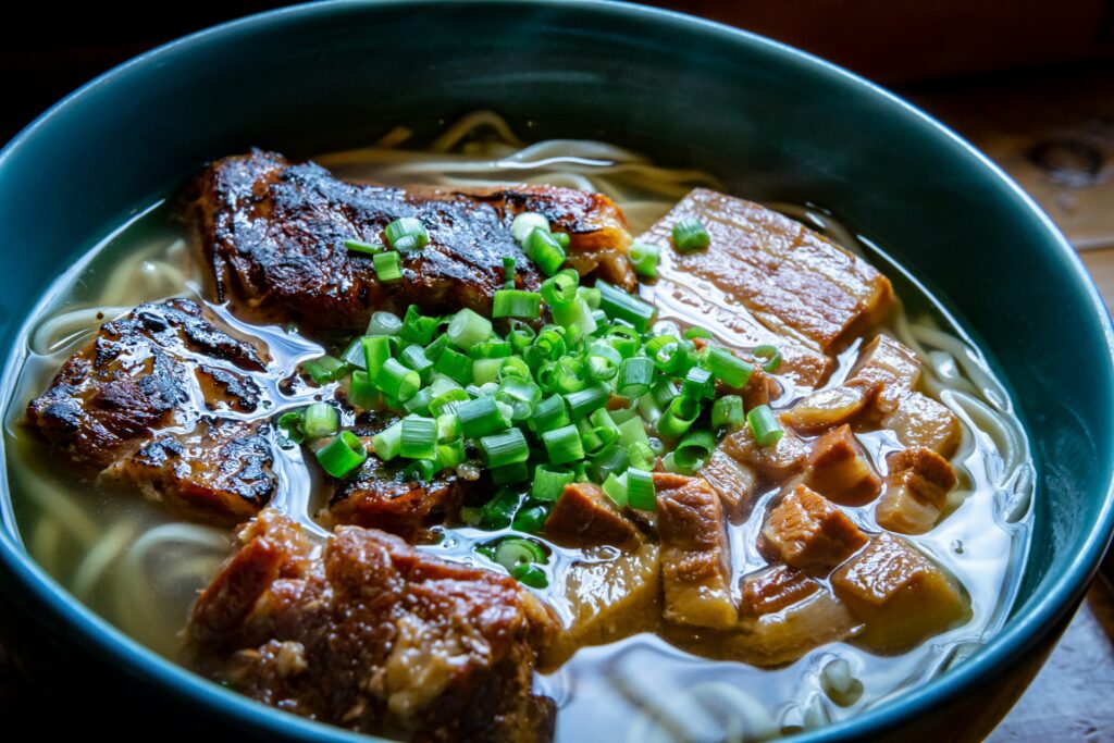 ソーキや三枚肉、ネギがたっぷりトッピングされた本場の沖縄そば